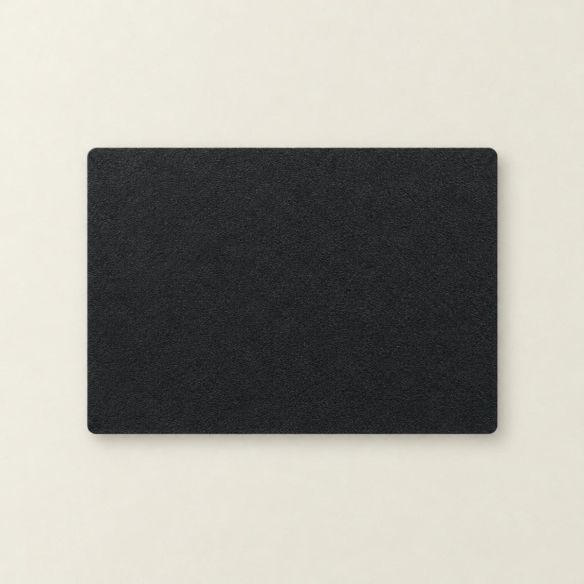 Rechthoekige placemat van zwart kunstleer met een subtiele textuur, plat neergelegd op een lichte ondergrond voor een strakke presentatie.