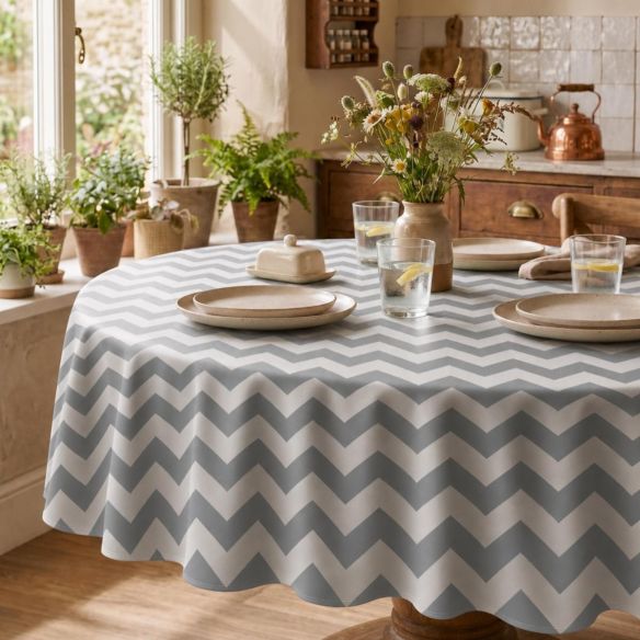 Rond Mexicaans tafelzeil ZigZag Zilver met een grijs-wit zigzagpatroon op een gedekte houten tafel in een landelijke keukenomgeving.