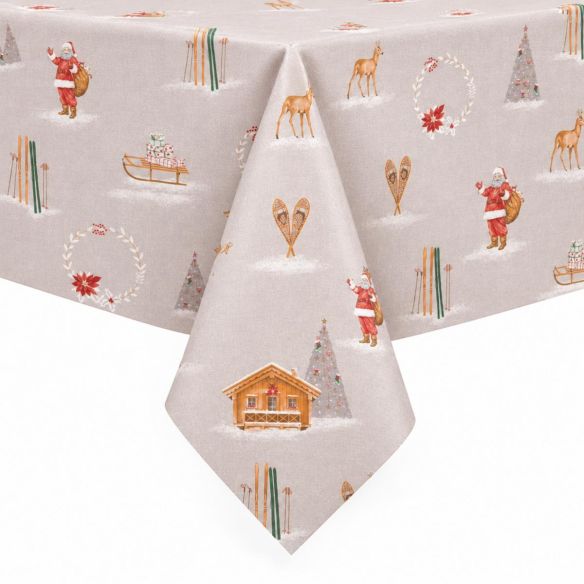 Tafelzeil Christmas Chalet Ecru met een kerstpatroon van chalets, de kerstman, herten en ski's op een lichtbeige ondergrond, over een tafel gedrapeerd.