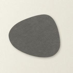 Placemat Floris in donkergrijs met een organische, asymmetrische vorm en een subtiele lederlook textuur, plat gepresenteerd op een lichte ondergrond.