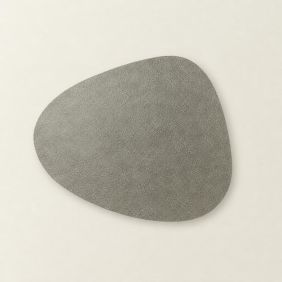 Placemat Floris in grijs zilver met een organische, asymmetrische vorm en een subtiele leerachtige textuur op een lichte achtergrond.