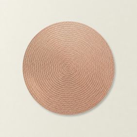 Ronde koperkleurige placemat Thora met een gevlochten structuur, gepresenteerd op een lichte achtergrond voor een strakke en moderne uitstraling.