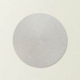 Een ronde zilverkleurige placemat Thora met een gevlochten structuur, gepresenteerd op een lichte achtergrond voor een strakke uitstraling.