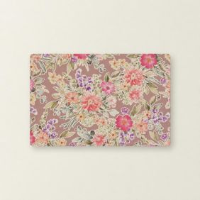 Rechthoekige placemat in taupe met een kleurrijk bloemmotief van roze, paarse en gele bloemen met groene bladeren op een effen lichtgekleurde achtergrond.