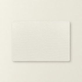 Rechthoekige ivoorkleurige Placemat Bodil met een subtiel krokodillenpatroon, plat neergelegd op een bijpassende lichte ondergrond voor op tafel.
