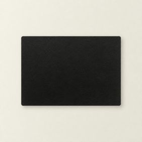 Een rechthoekige zwarte Placemat Ava van 30x43 cm met een subtiele lederlook textuur, plat neergelegd op een lichte, neutrale ondergrond.