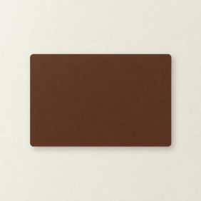 Een rechthoekige placemat van gerecycled leer in de kleur nutmeg met afgeronde hoeken, plat neergelegd op een lichte, neutrale ondergrond.