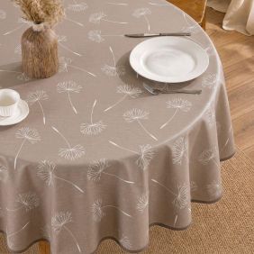 Rond beige tafelzeil met wit paardenbloemmotief, gedekt op een tafel met servies, een vaas en een zachte molton onderlaag voor extra bescherming.